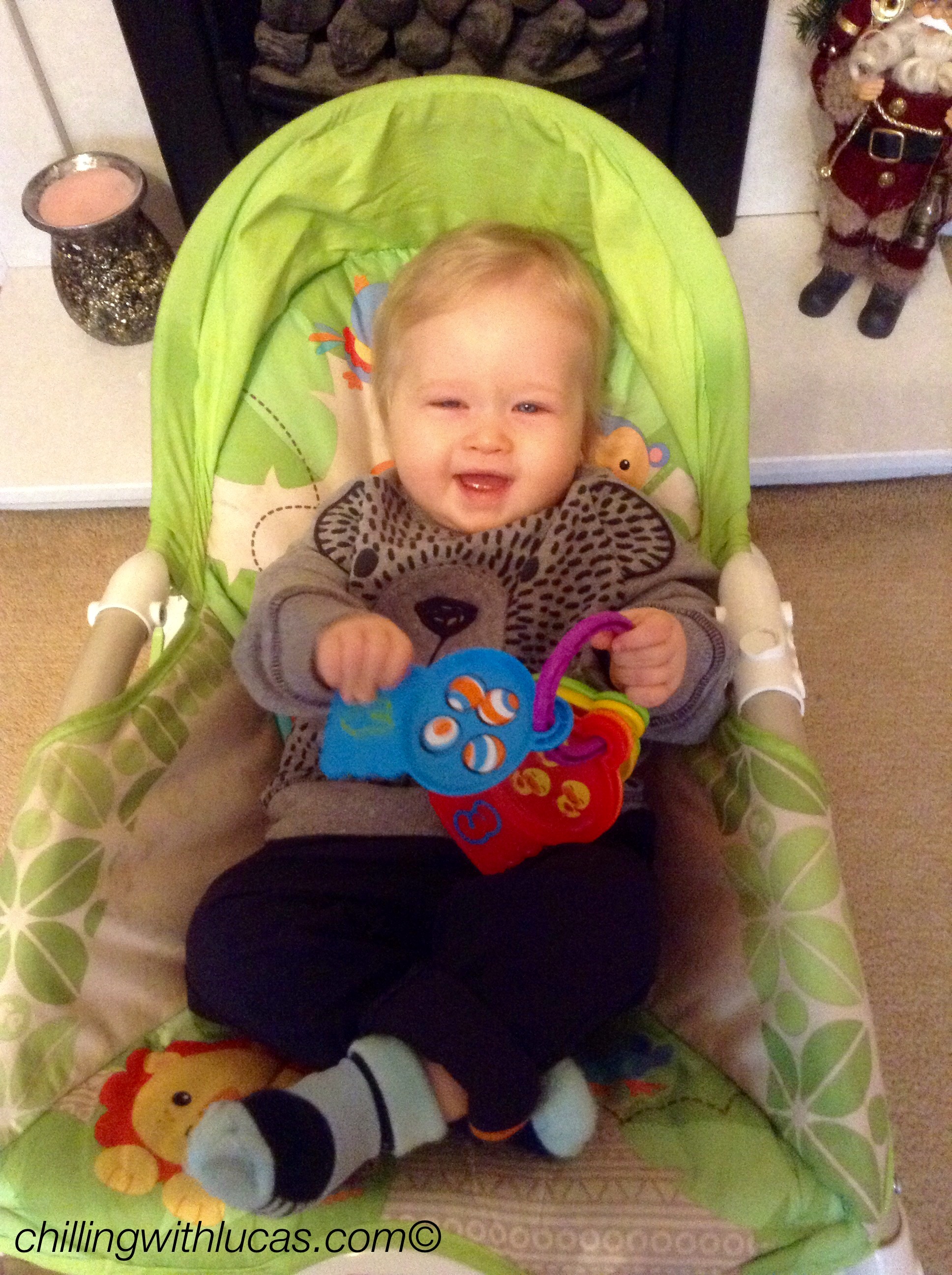Lucas sitting in his chair wearing navy trousers and a grey bear jumper