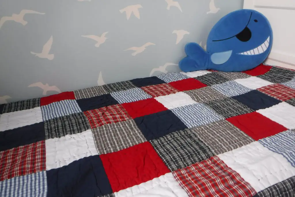Transitioning from co-sleeping to own bedroom. babyface blue red and white patchwork quilt