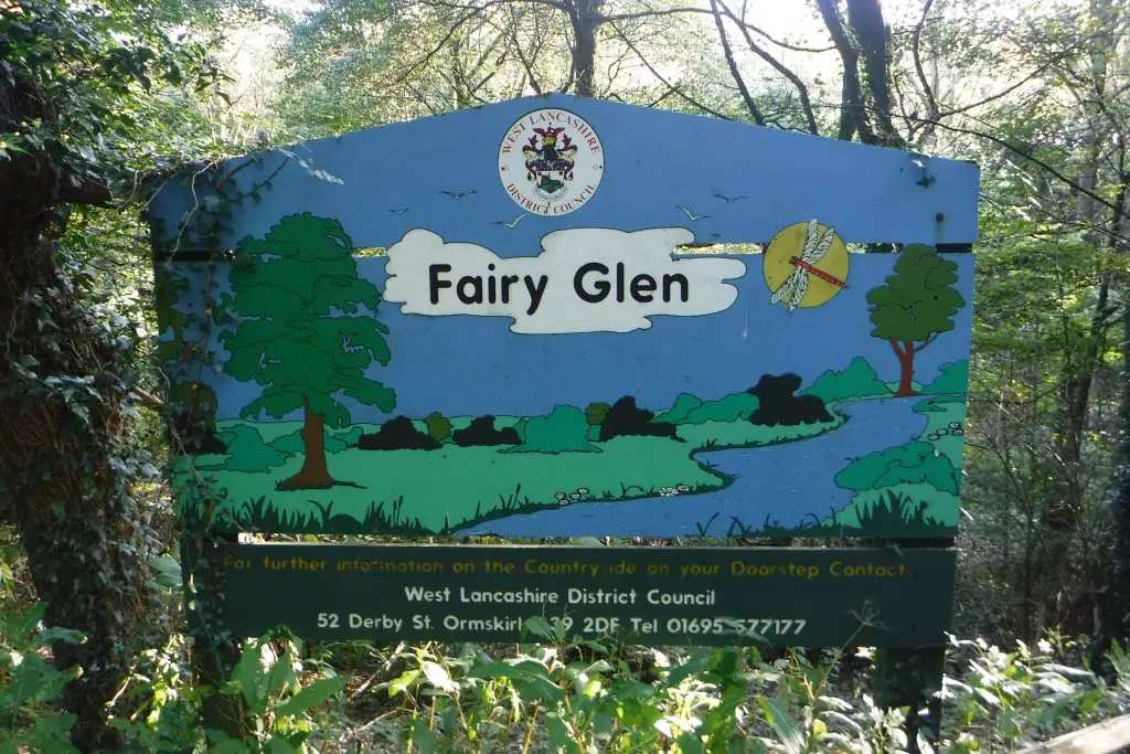 Free days out in Lancashire #mamiadaysout the sign for the fairy glen, a blue sign with green meadow and trees