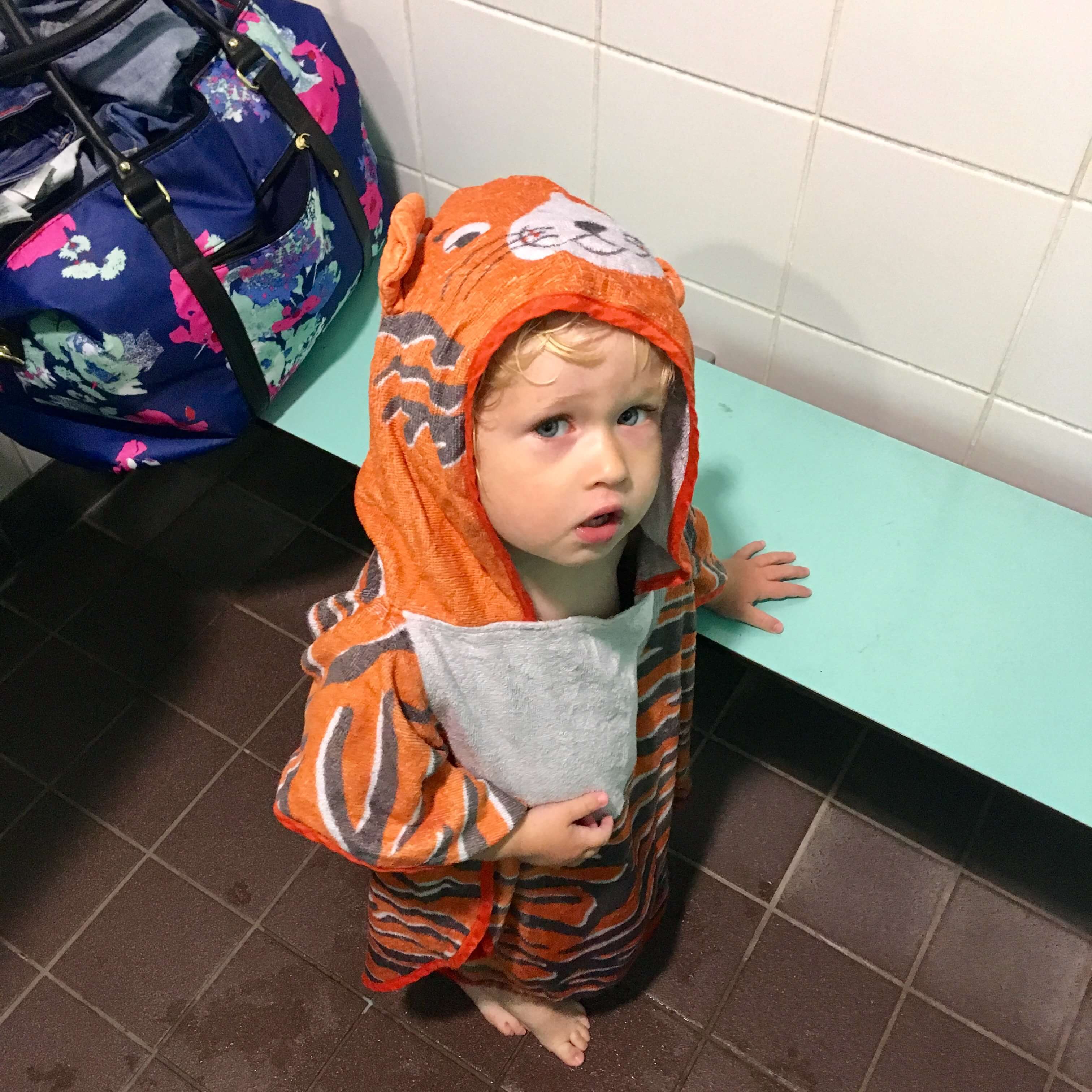Ordinary moments. Lucas stood in a changing room wearing a tiger hooded towel looking at the camera