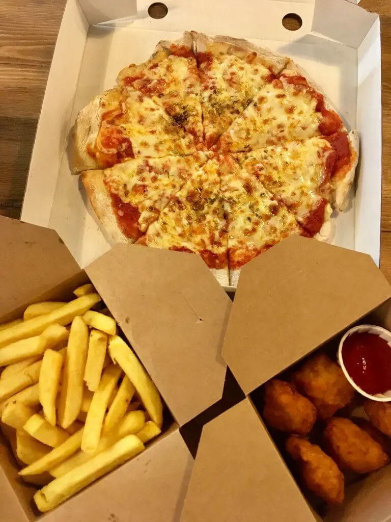 Flip Out Blackburn - trampoline park review 3 brown cardboard food boxes, the top with a cheese and tomato pizza in, the left at bottom chips and eight chicken nuggets