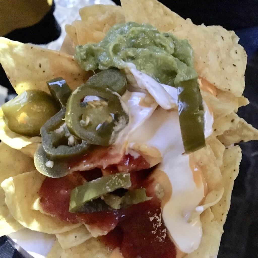 Haigh foodie Friday review A polystyrene tray filled with nachos topped with green jalapeños salsa guacamole sour cream and melted cheese