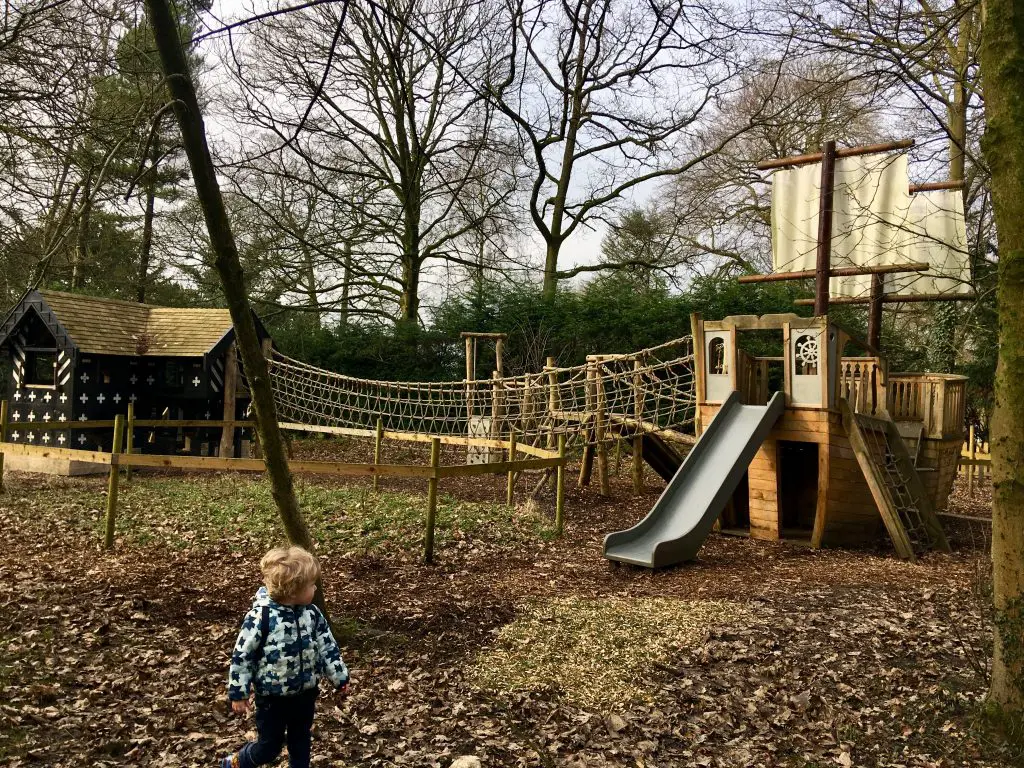 Samlesbury Hall, Preston. Lucas is stood in front of a wooden play area