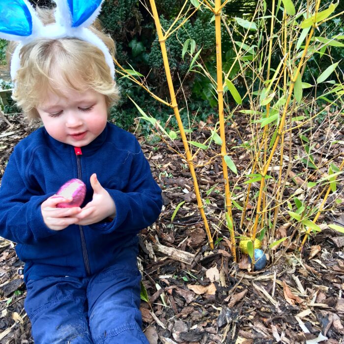 Easter egg hunt, Lucas is sat looking at the pink foiled egg he has just picked up