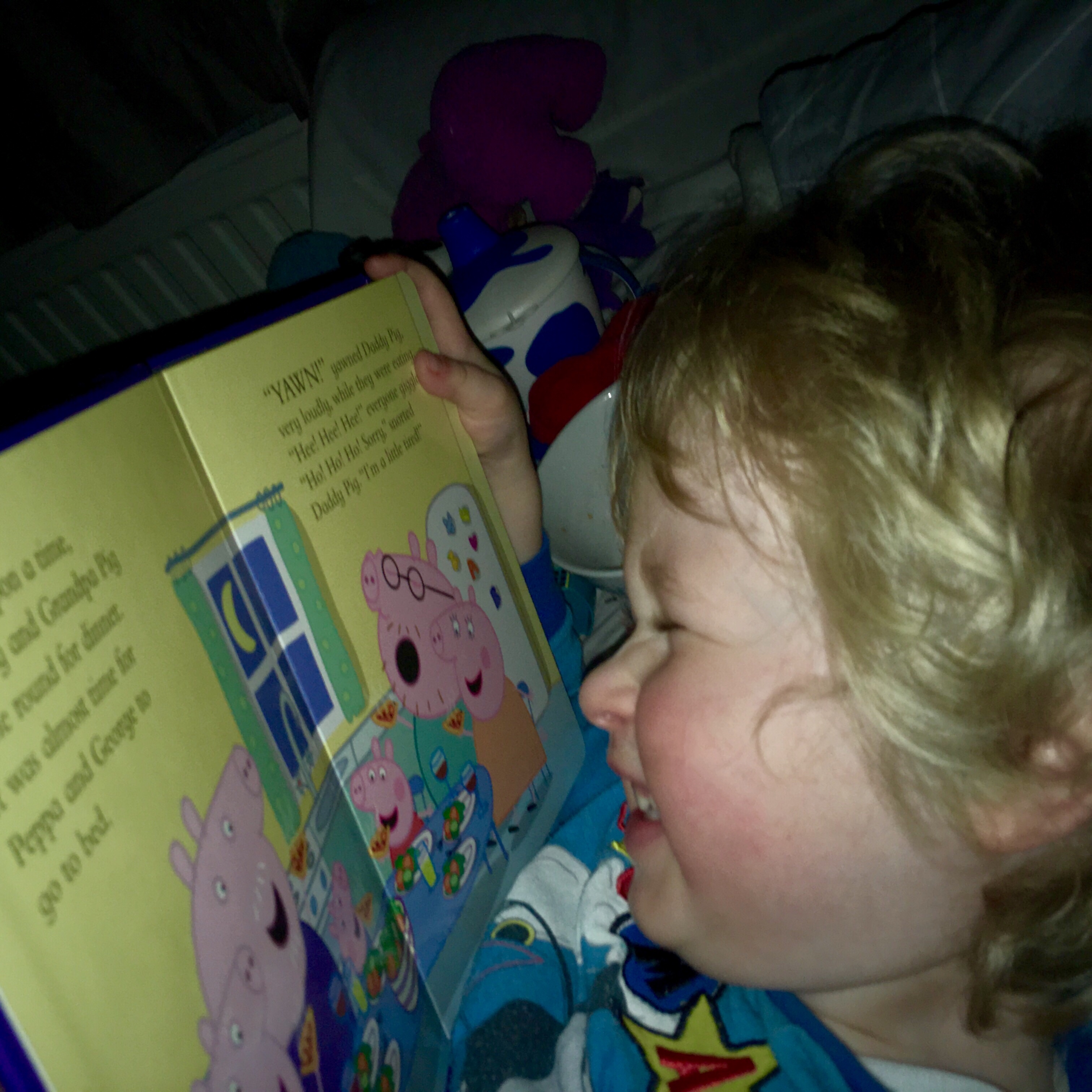 Bath, book, bed (and maybe a little creativity) Lucas has blonde wavy hair he is smiling at a book, the camera has a side on angle