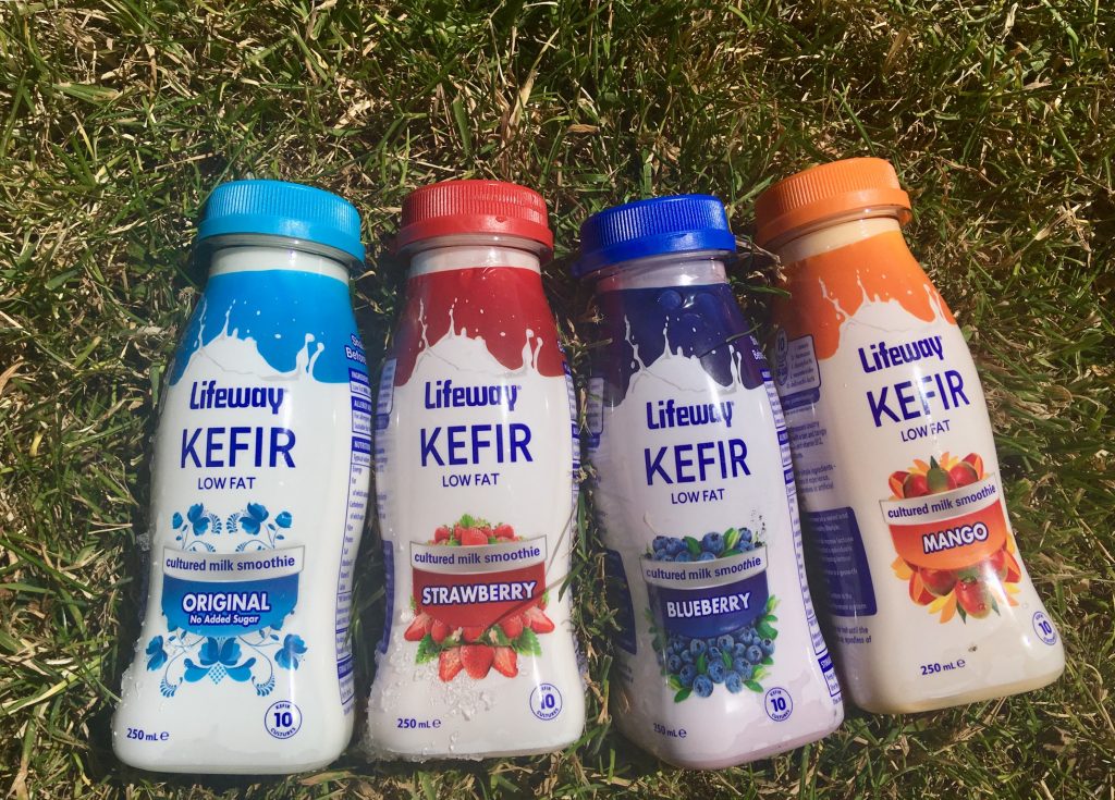 Lifeway Kefir review. Four bottles led against grass, one original, one mango, one blueberry and one strawberry 