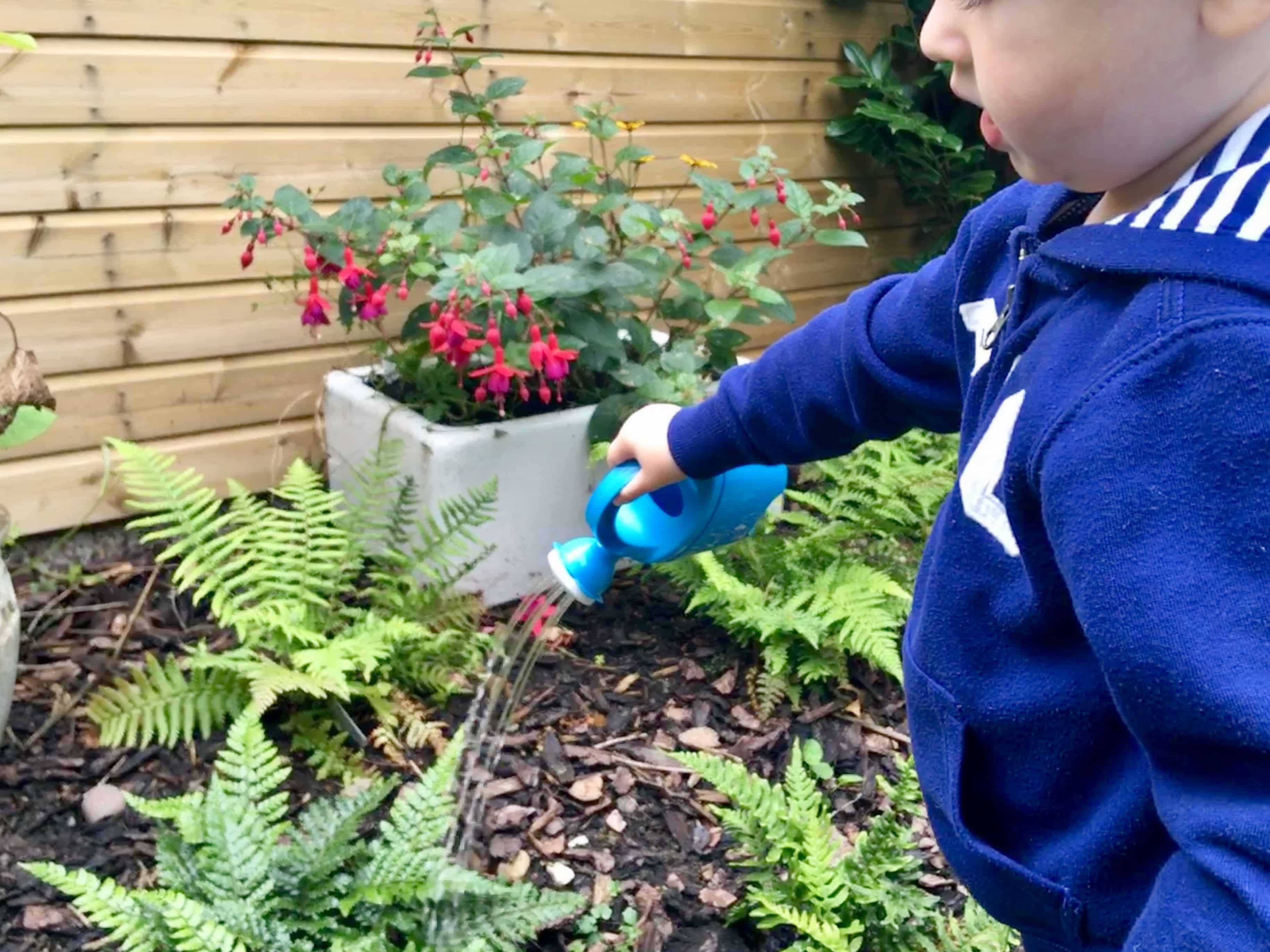 Celebrating outdoor play, every day Lucas watering plants with a small watering can