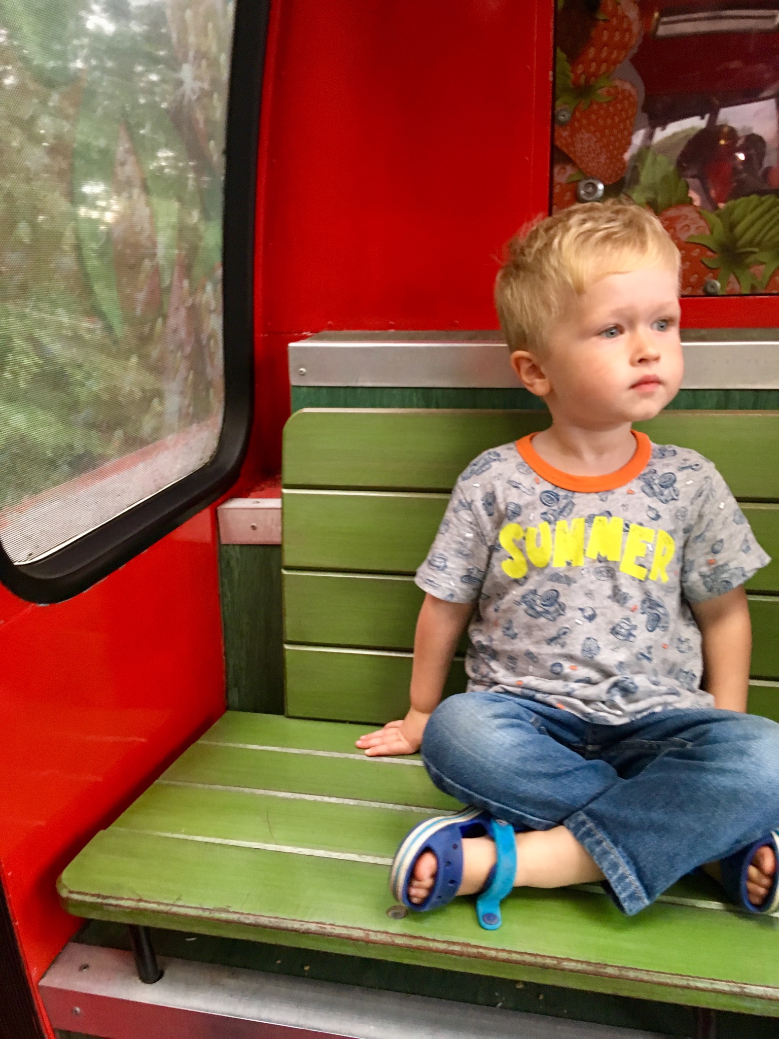 Lucas sitting on a tram on looking to the side