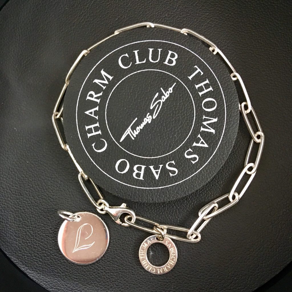 Peter Jackson Jewellers discount code. A close up of the silver thomas Sabo bracelet and silver circle charm engraved with L