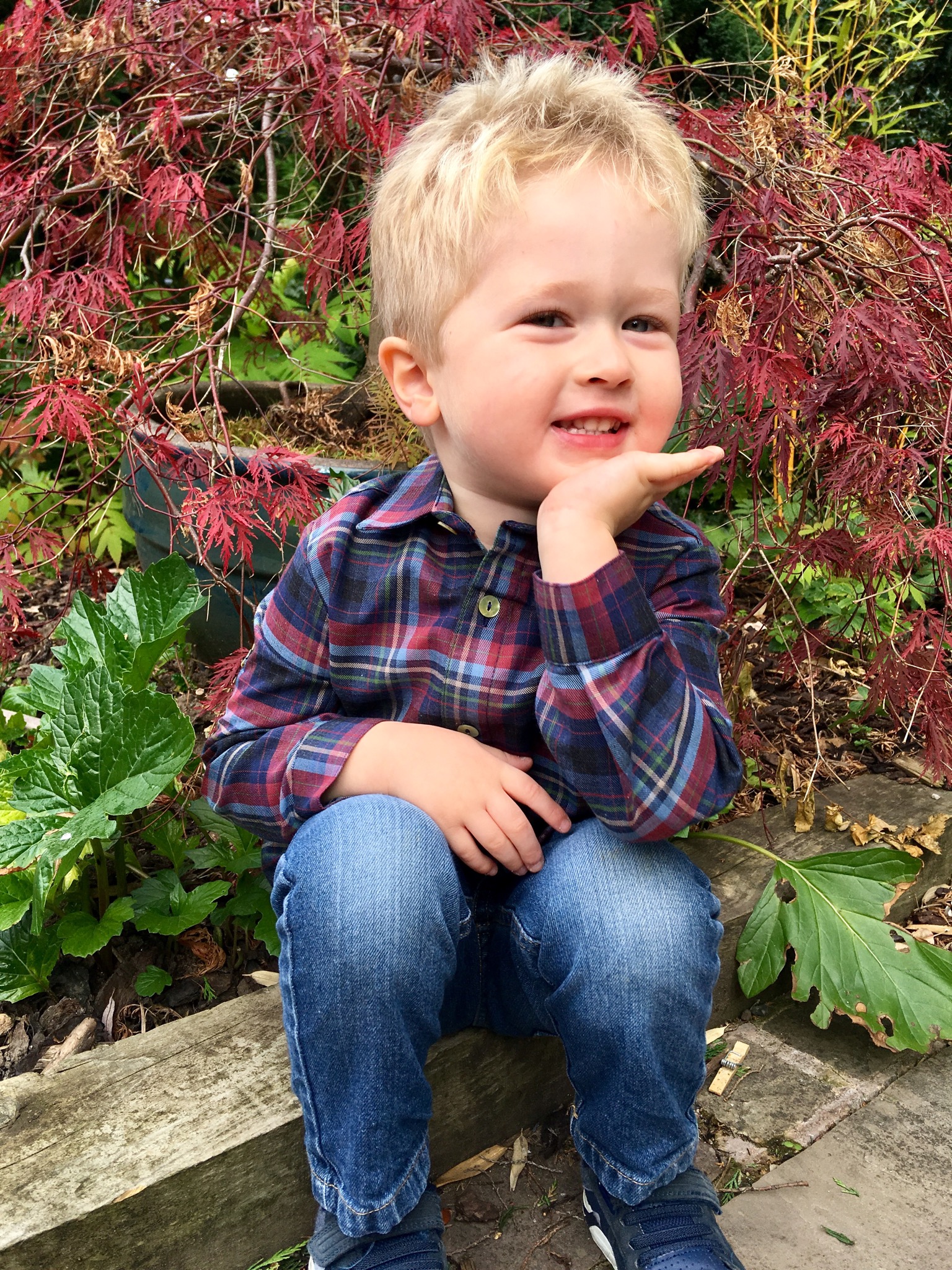La Coqueta Lucas is sat smiling at the camera wearing the shirt and jeans