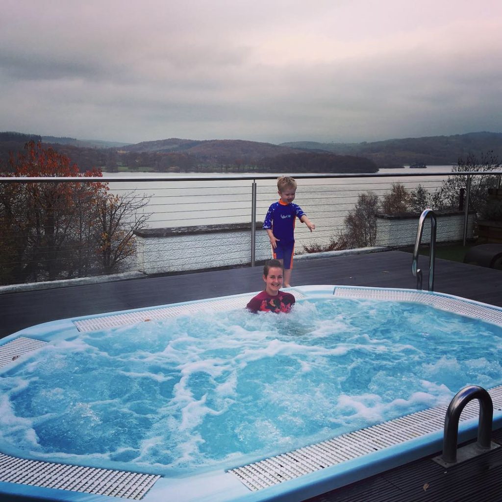 Beech Hill Hotel and Spa, Windermere review I’m in the outside jacuzzi and Lucas is stood behind me, behind us is lake windermere
