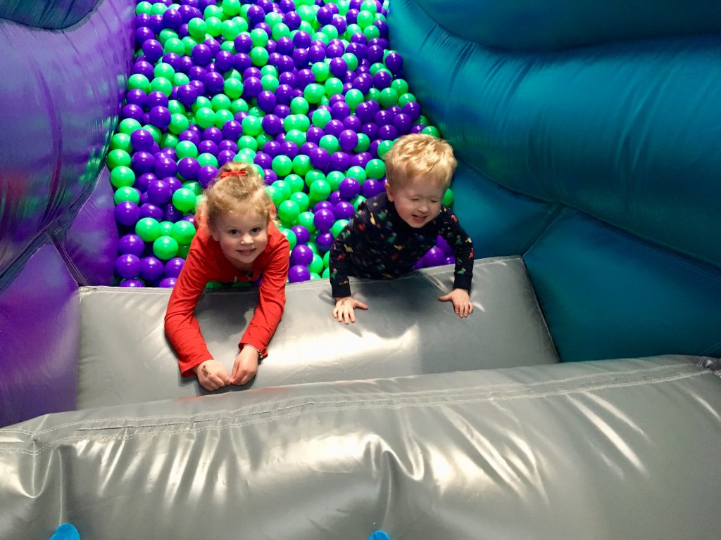 Air Unlimited Burnley review. Lucas and S stood in aballpool and looking up at camera leant on grey inflatable steps