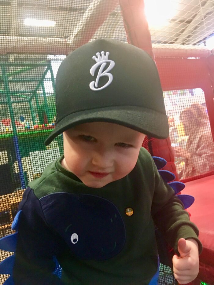 lucas with his thumb up, looking at the camera wearing a black baseball hat