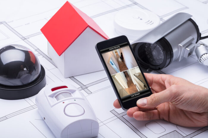 7 Things to Consider Before Buying a Home Security System. Photo of Architect Using Home Security System On Mobile Phone