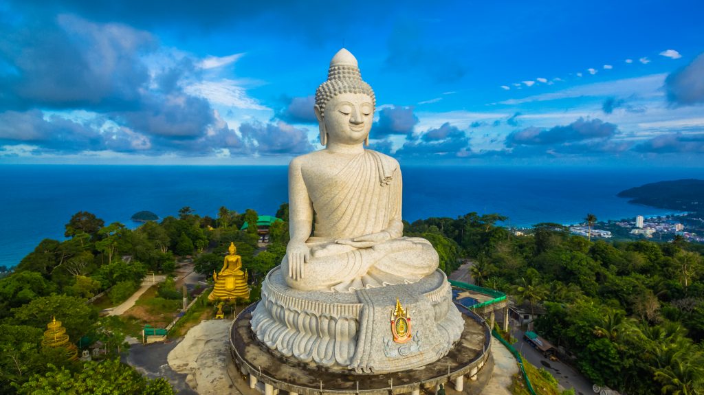 Visiting Phuket with children. blue sky and blue ocean are on the back of Phuket Big Buddha statue.white Phuket big Buddha is the one of landmarks on Phuket island.