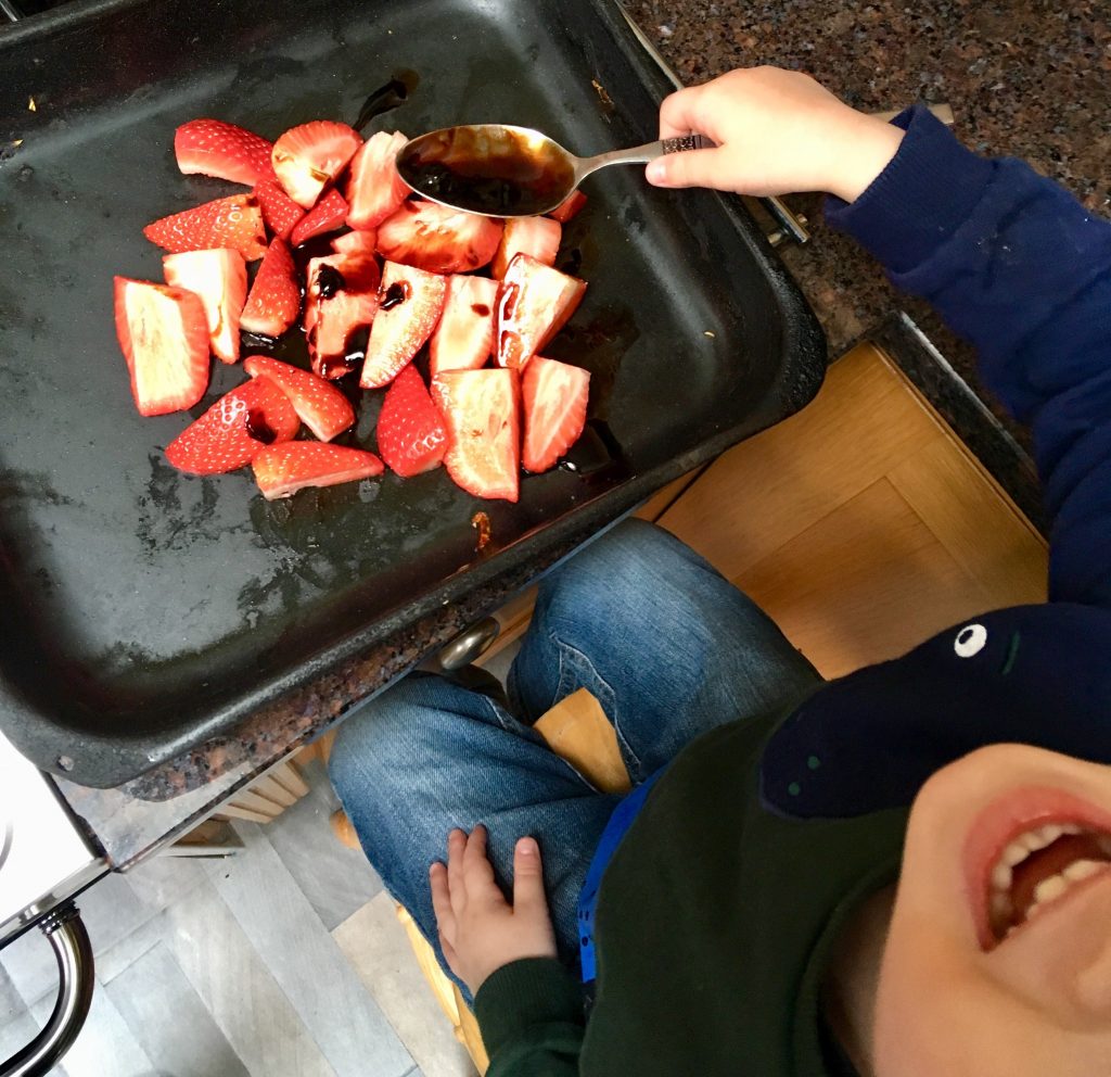 Get Your Kids to Eat Anything - Strawberries and Cream Pasta. Lucas is putting on balsamic vinaigrette on the strawberries 