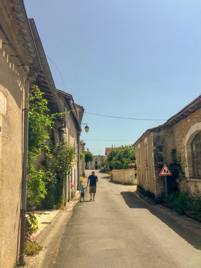 Lucas and D walking along a French village road