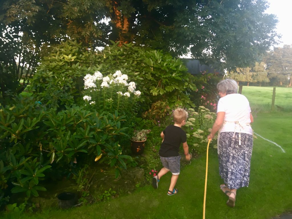 Lucas and grandma watering the garden 