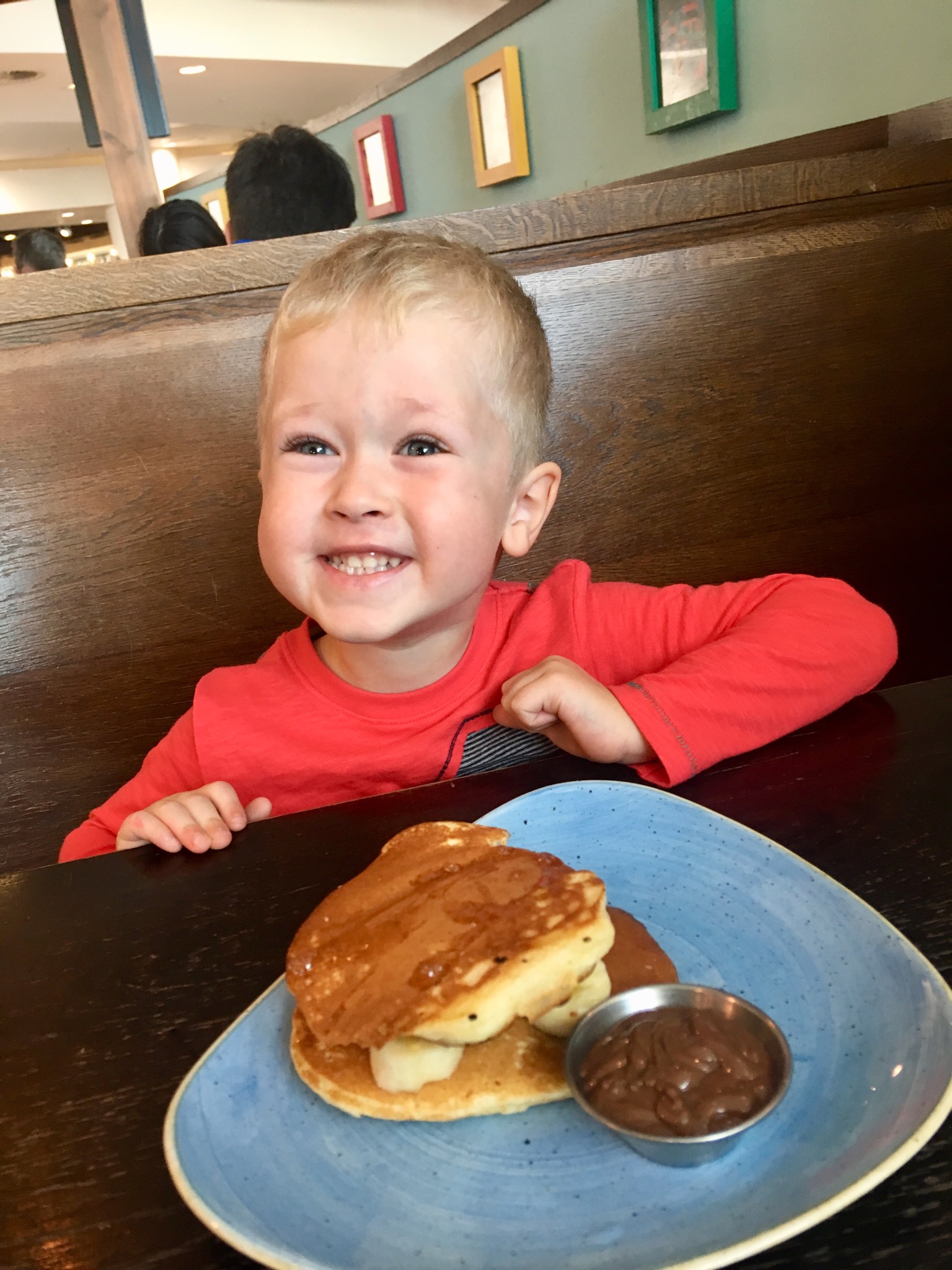 Lucas at giraffe restaurant in Manchester airport with pancakes and Nutella and banana