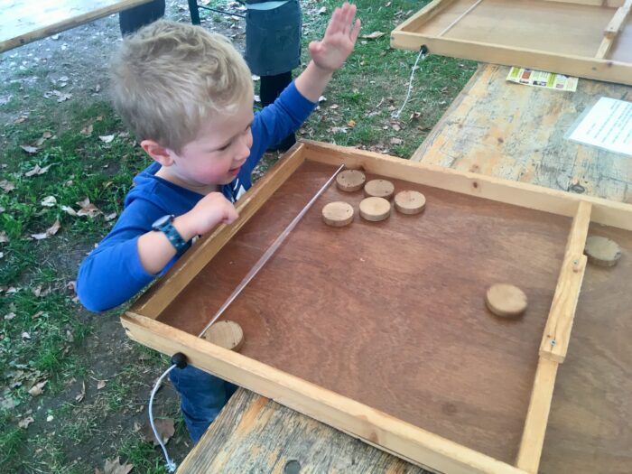 Lucas playing an outdoor wooden game
