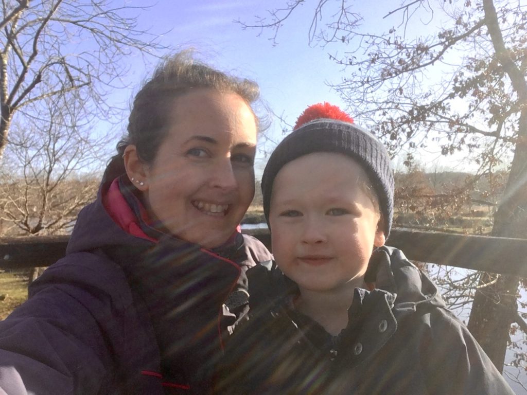Lucas and I looking at the camera smiling. You can see trees and blue sky behind us 