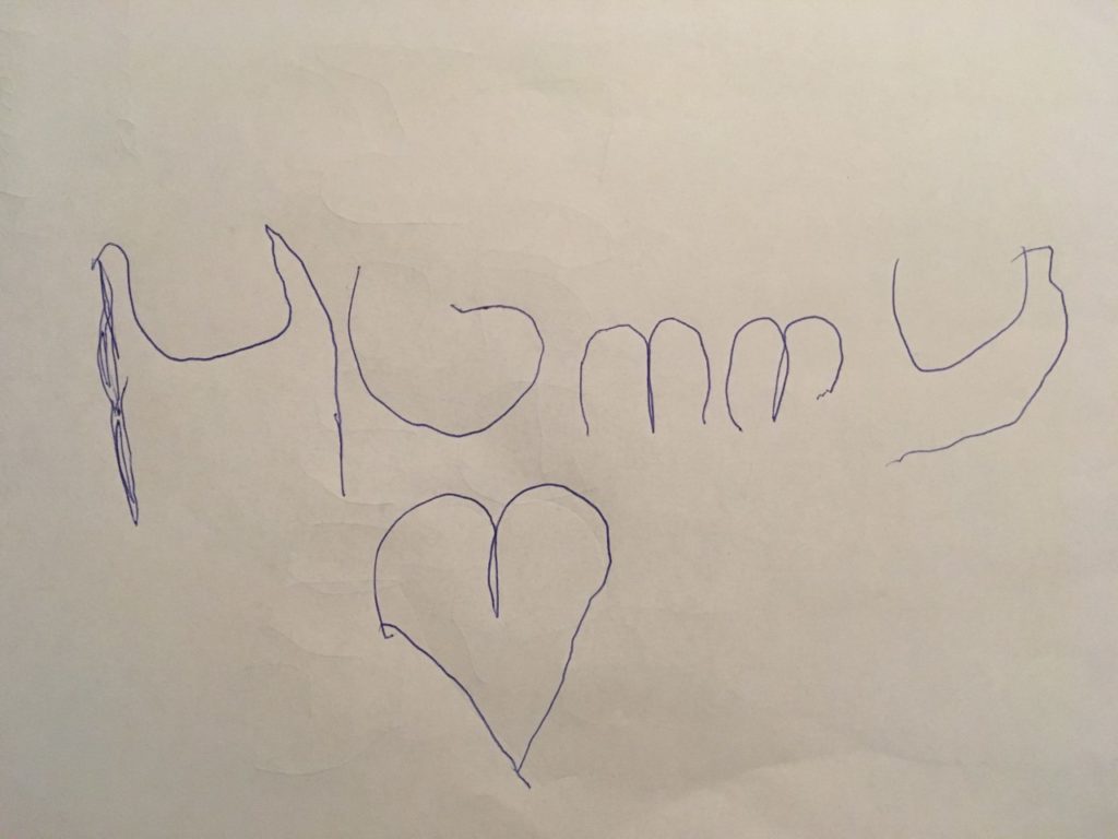 Lucas' writing saying Mummy on a4 sheet of white paper