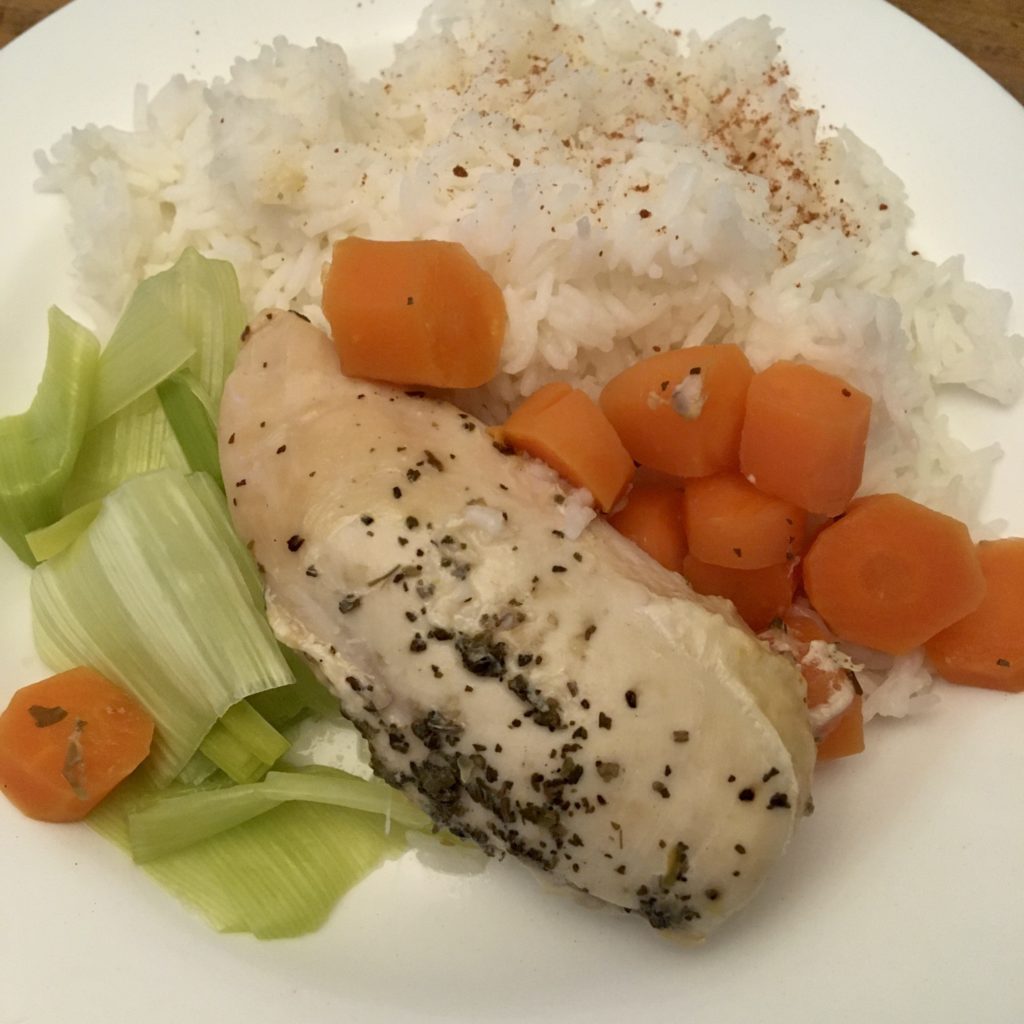 Lemon and basil chicken on a white plate served with rice, carrots and leeks 