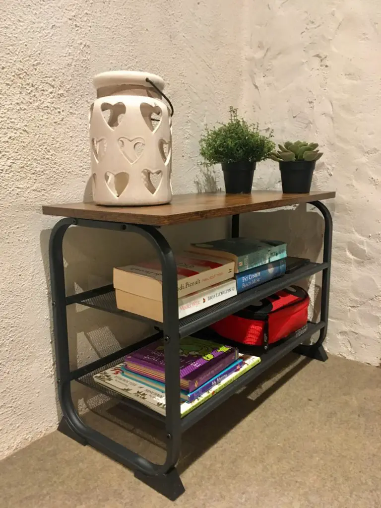 The vasagle shoe bench with a cut out heart candle holder and plants on the top, books on both mesh shelves