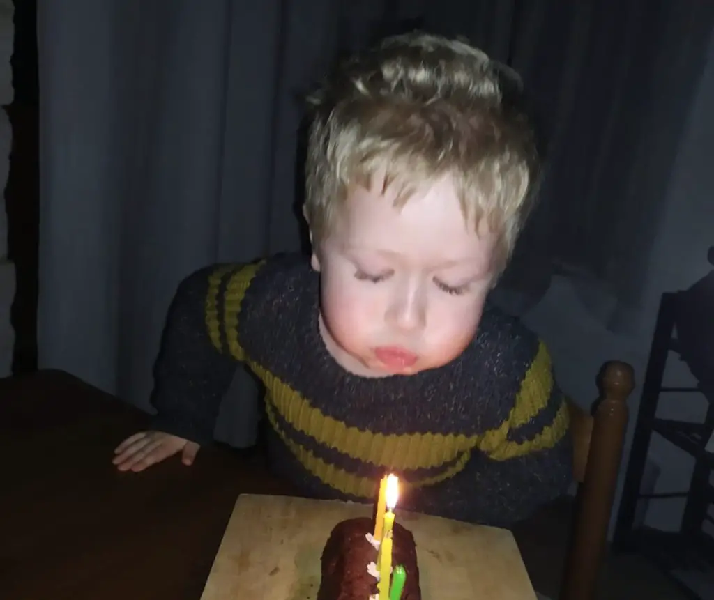 Lucas blowing candles out on his cake