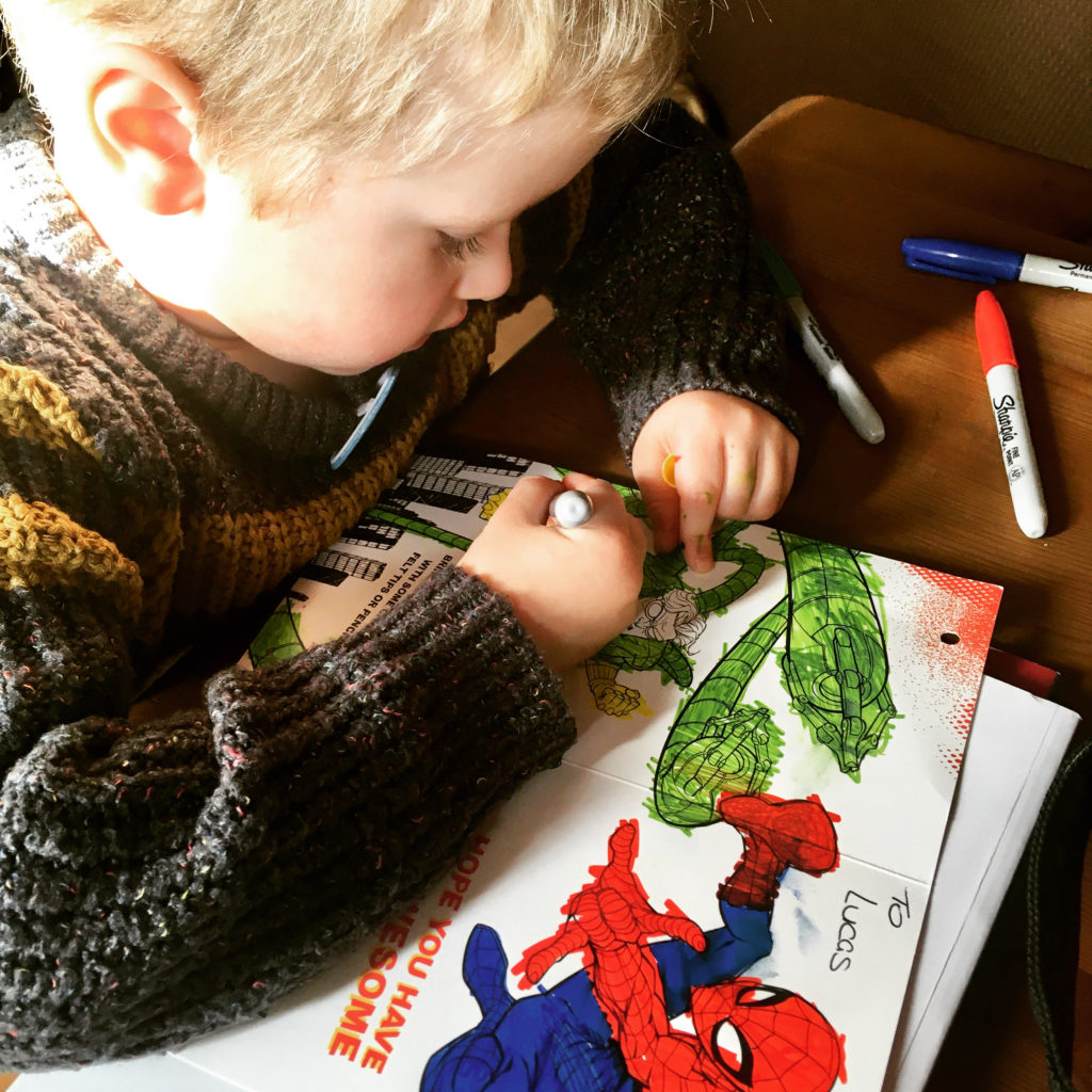 Lucas colouring the inside of his Spider-Man birthday card 