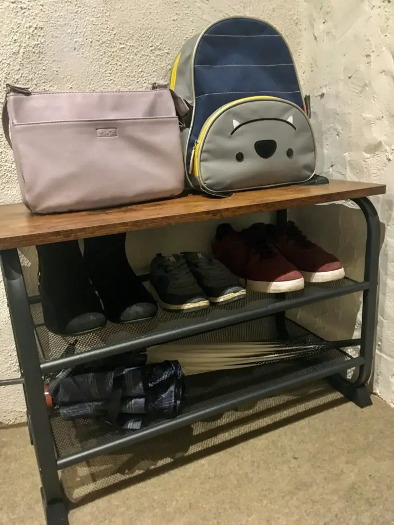 The vasagle shoe bench with my handbag and lucas backpack on the top, shoes on the middle shelf and umbrellas on the bottom shelf