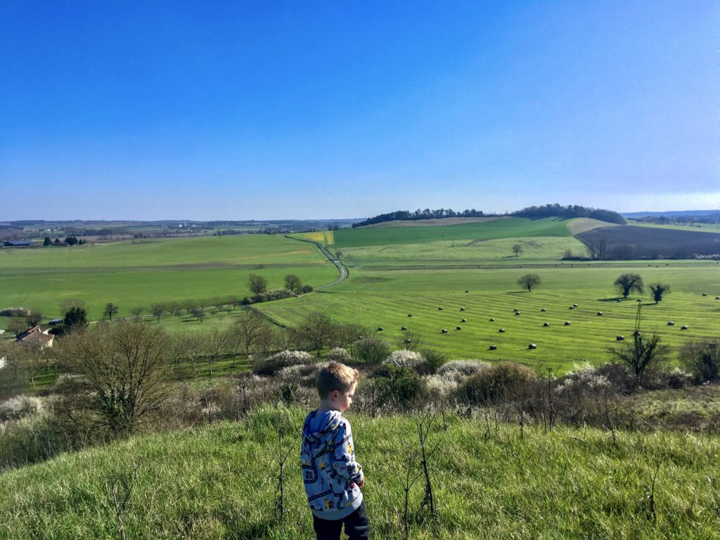 Lucas walking on a hill, you can see countryside for miles around 