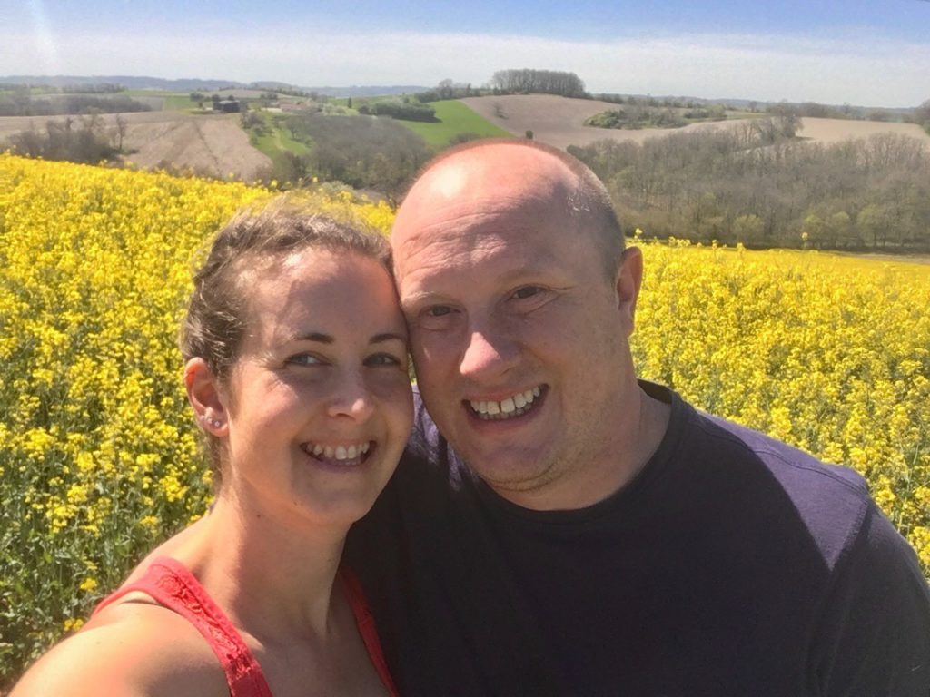 A close up of D and I I’m front of yellow rapeseed field 