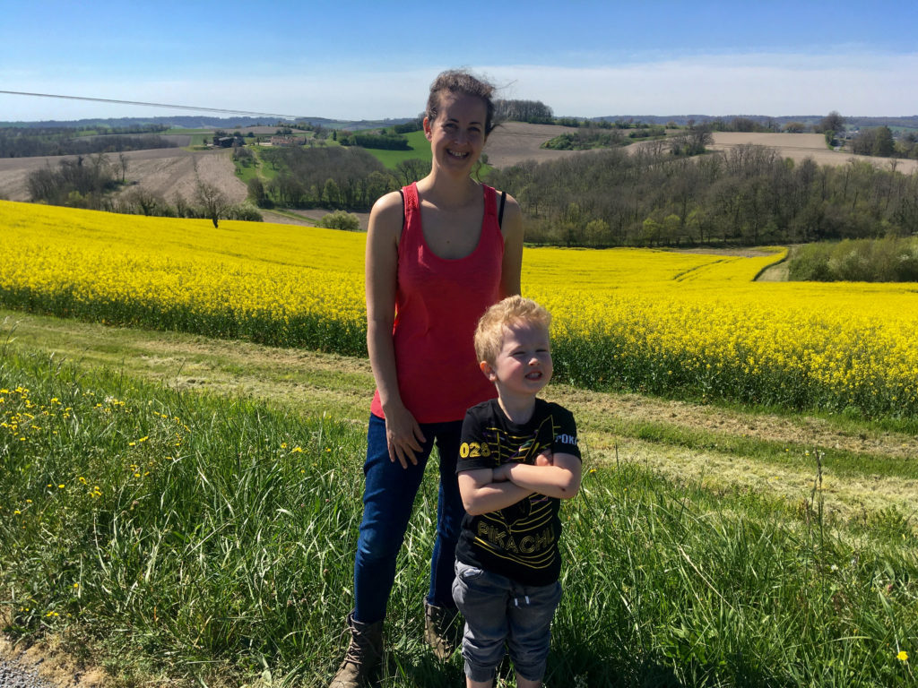 Lucas and I stood in front of a yellow rapeseed field on a sunny day 