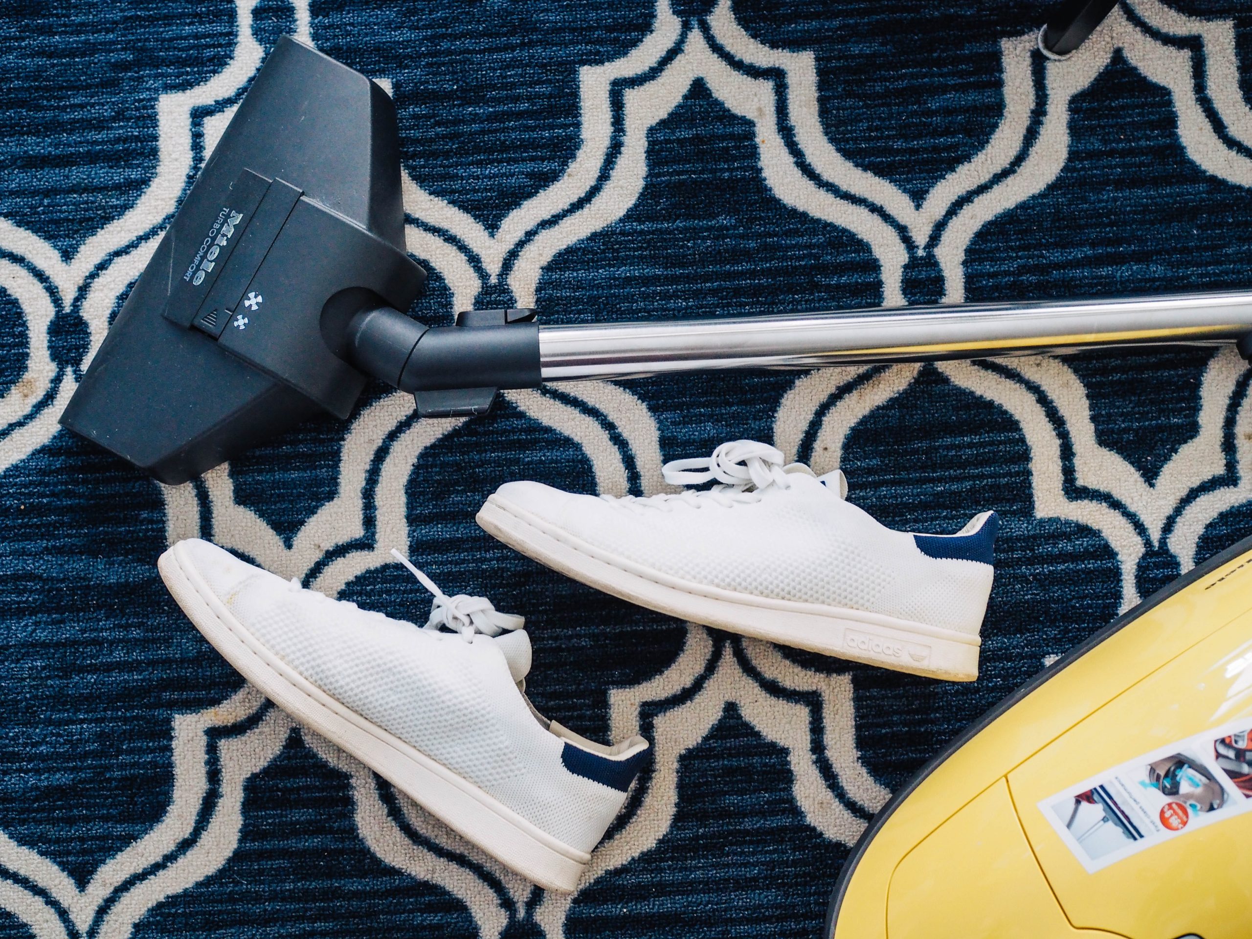 a vacuum next to white trainers