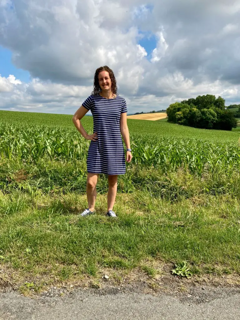 I’m wearing a navy and white Tshirt dress with fields behind me 