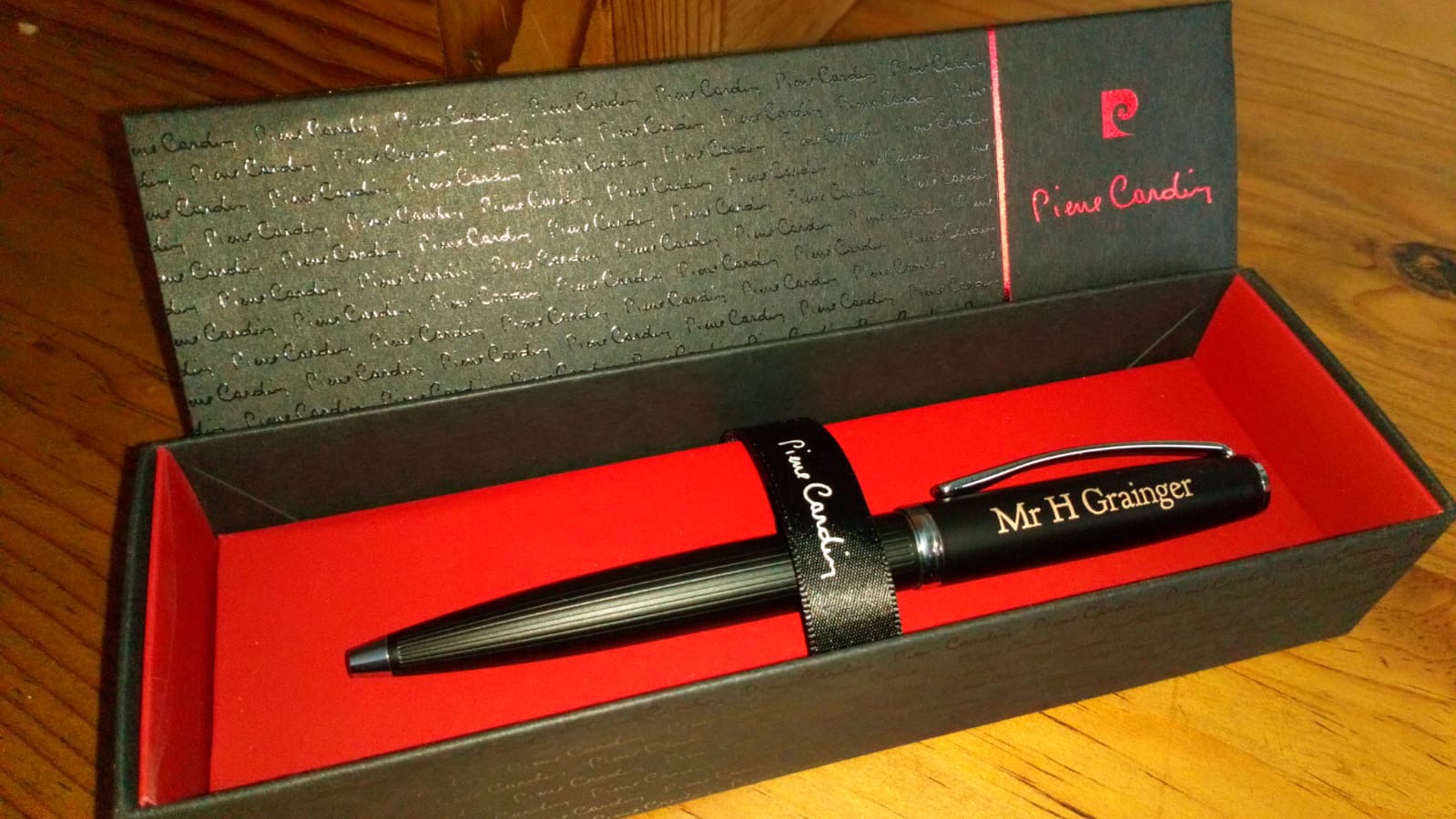a black personalised pen with mr h grainger emgraved onto it, the pen is in a black box with a red lining