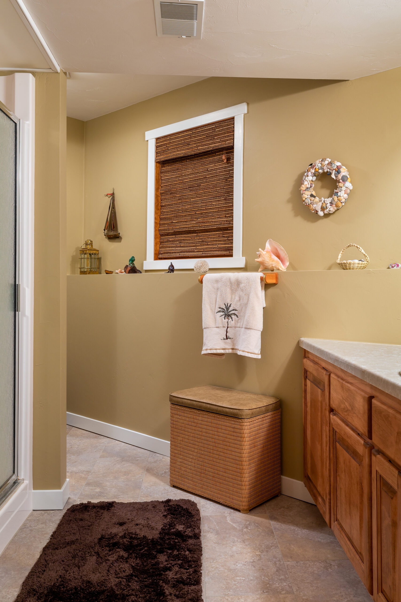 Beach themed guest bathroom that has been remodeled with luxury vinyl tile flooring.
