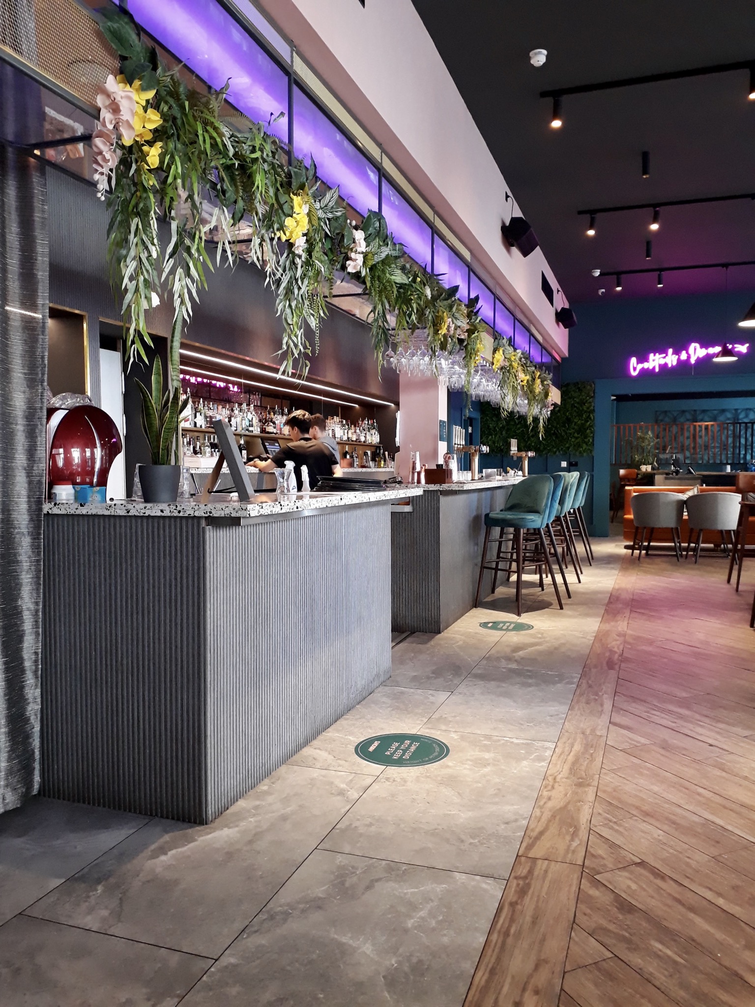 The inside of Mason’s Liverpool restaurants you can see a grey bar area with flowers hanging above
