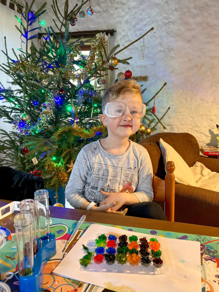 Lucas with protective goggles on doing rainbow gem experiments 