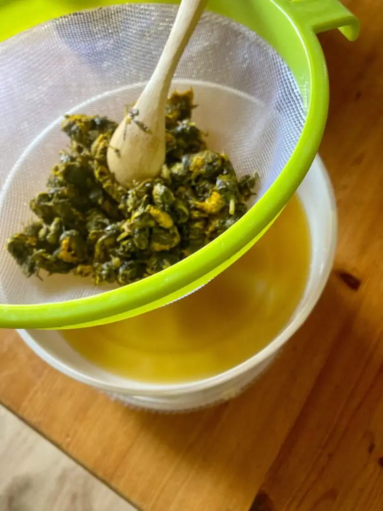 draining the dandelion juice through a sieve into a bowl