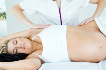 a lady having a pregnancy massage