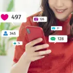 influencer holding phone with likes and message count symbols showing