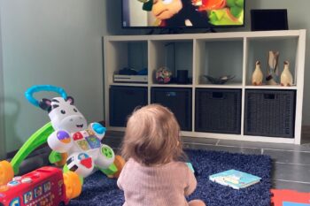 Morgana sat on the rug watching babytv