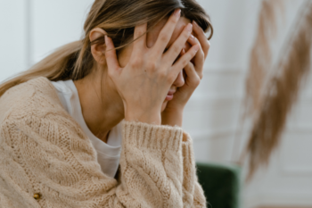 stressed woman with her hands over her face