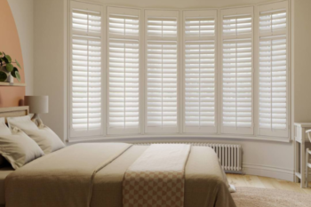 cream bedroom with white bay window shutters