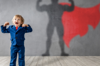 a young boy wearing a suit with his armsclenches and his shadow behind him is a superhero