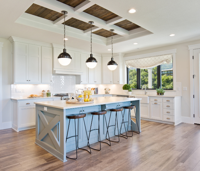 open plan kitchen with white cupboards and a kitchen island with stools