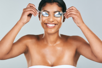 lady holding sppons on her eyes to reduce puffy eyes