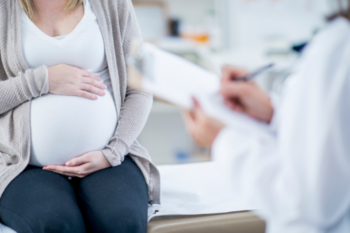 pregnant lady sat down talking to a medical professional